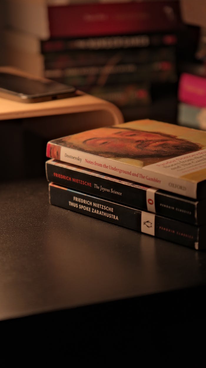About Cozy evening scene with classic philosophy books stacked on a desk.